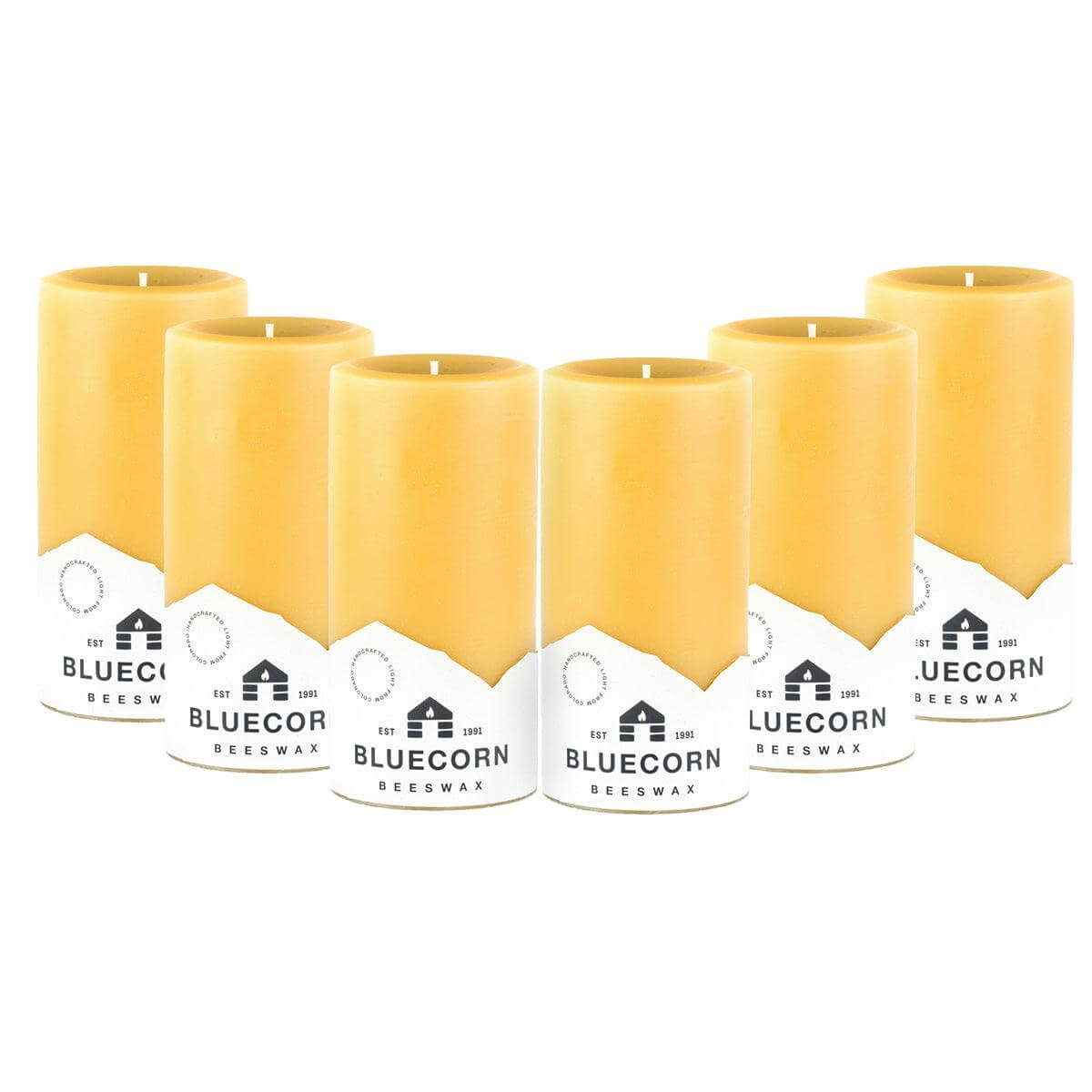 Set of six yellow candles with white labels on a white background