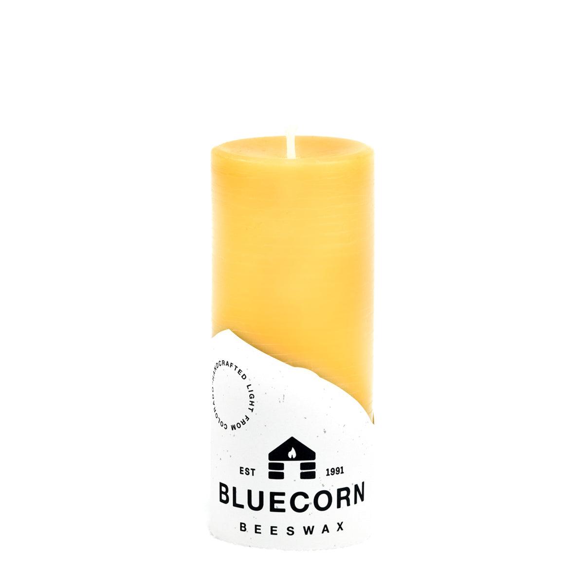 Yellow beeswax candle with Bluecorn Beeswax packaging on a white background