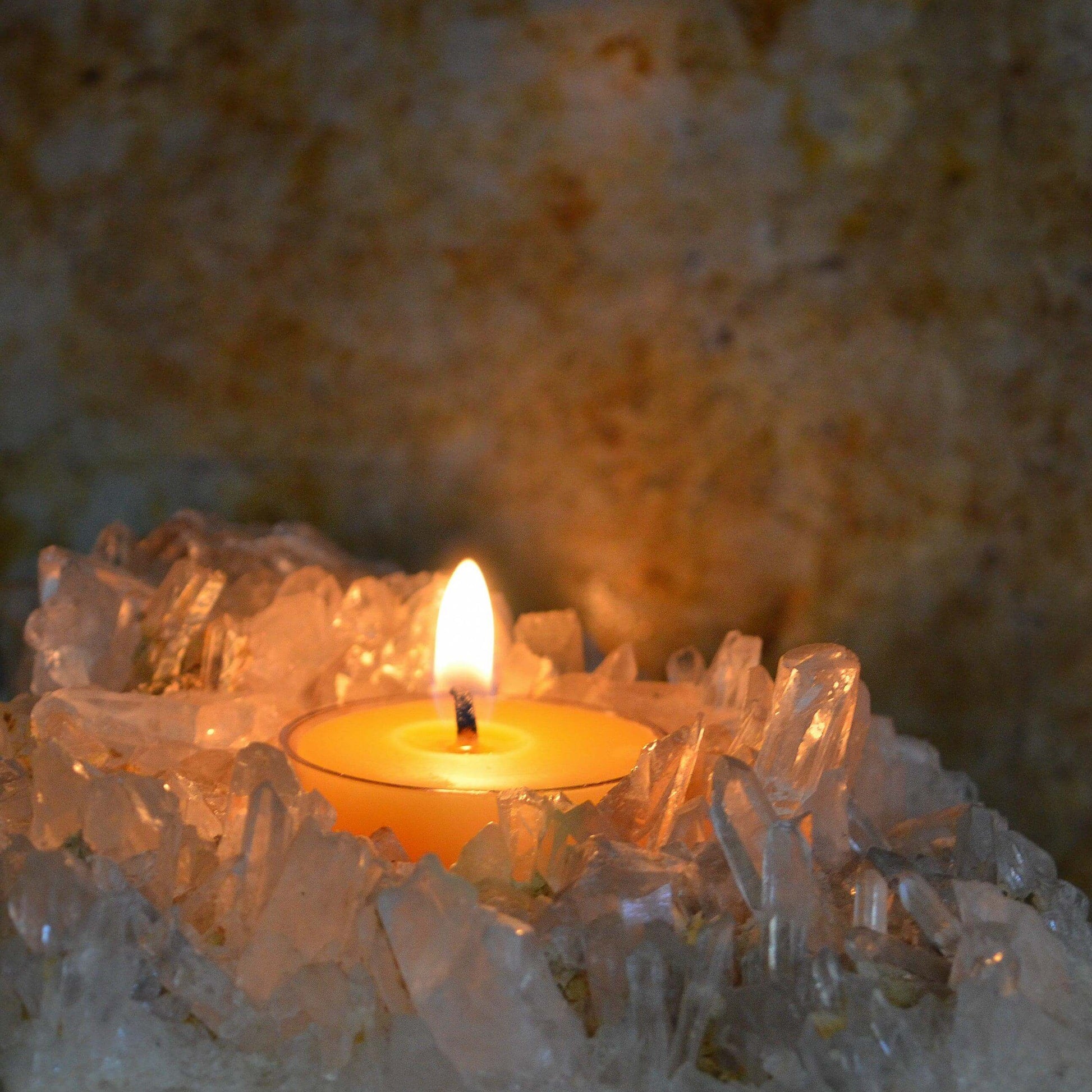 Candle in a crystal holder with a blurred natural background