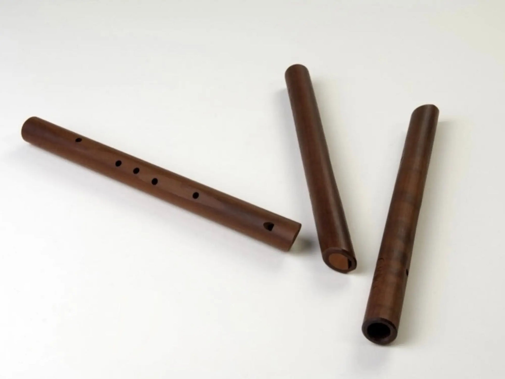 Three pear wood pentatonic flutes on a white background
