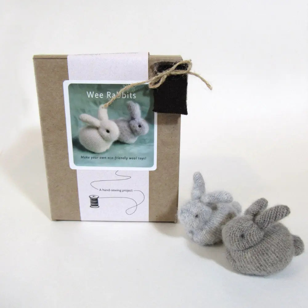 Knitted rabbits with a cardboard box and label on a white background