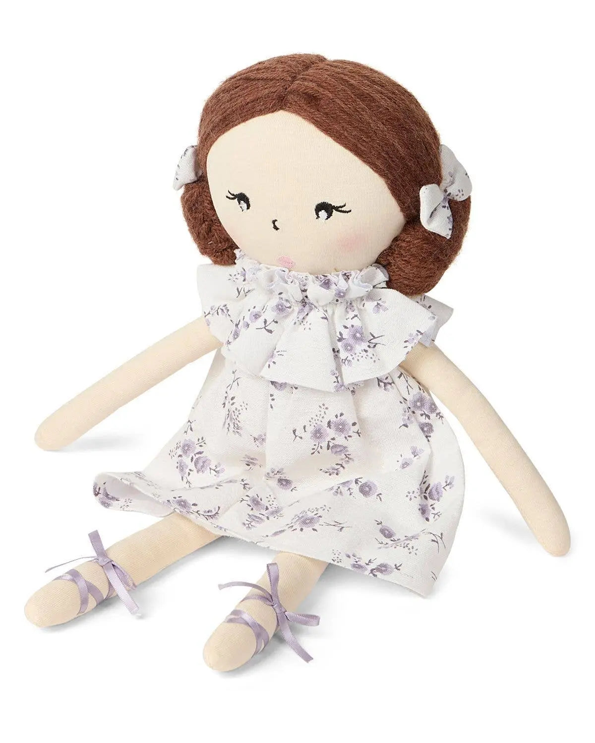 Textile doll with brown hair and a floral dress on a white background
