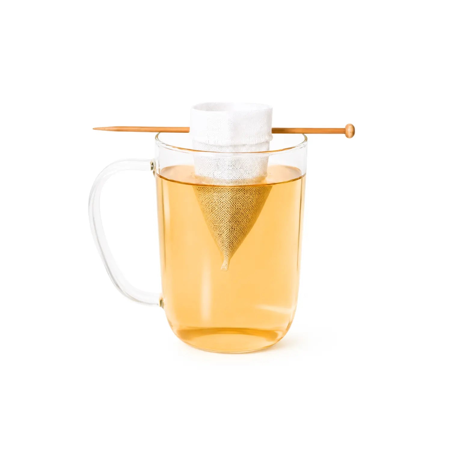 Reusable organic cotton tea bags with wooden balancing stick, loose-leaf tea, and ceramic mug
