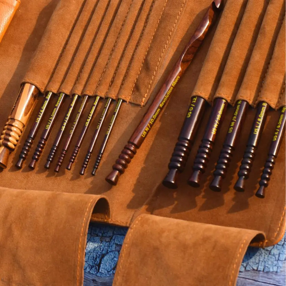 Set of wooden tools with metal tips on a leather case.