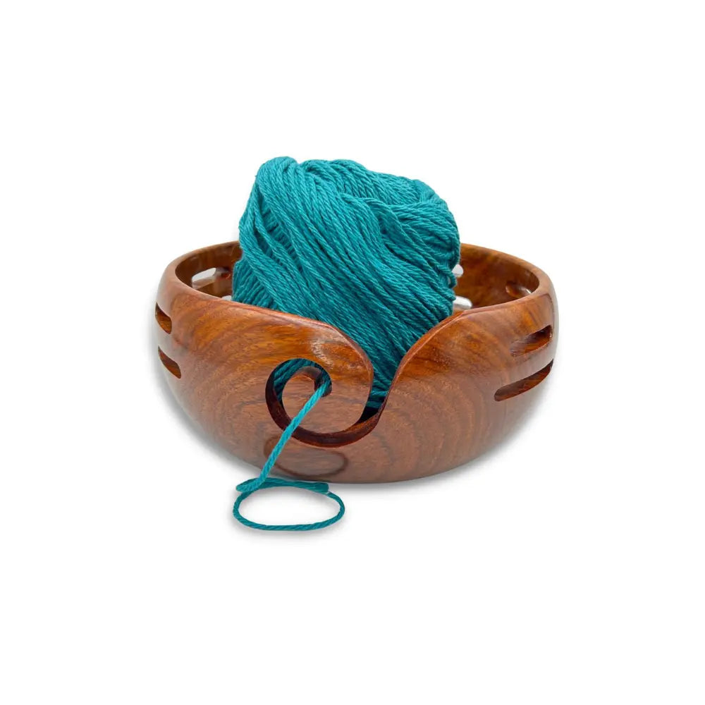 Wooden yarn bowl with teal yarn on a white background