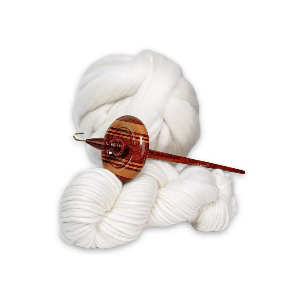 Wooden top whorl drop spindle with white yarn on a white background
