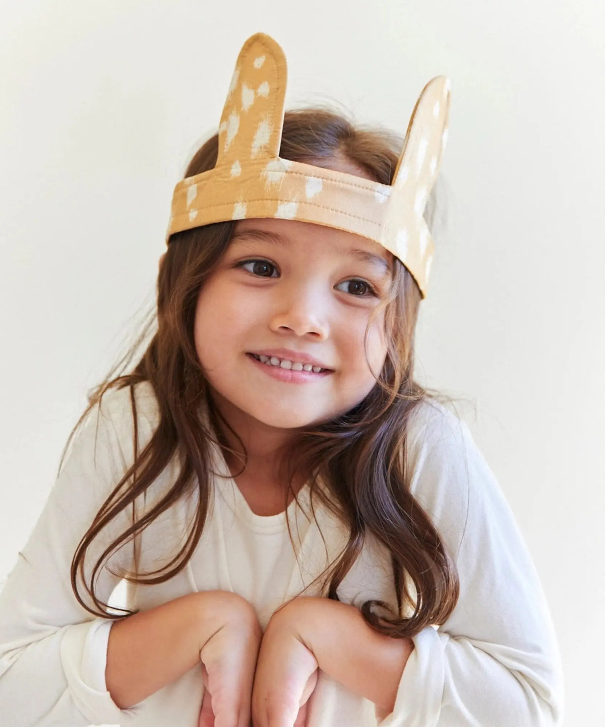 Child smiling while wearing Sarah’s Silks fawn ears