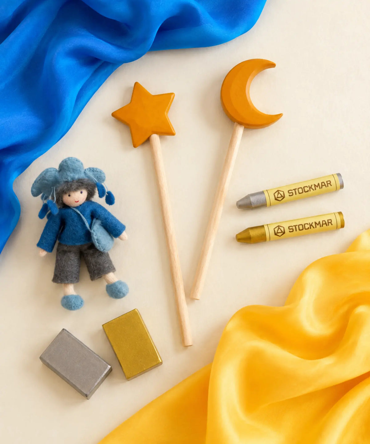 A cloud fairy with a moon and star wooden wand set, gold and silver Stockmar crayon set, and a blue and gold mini silk