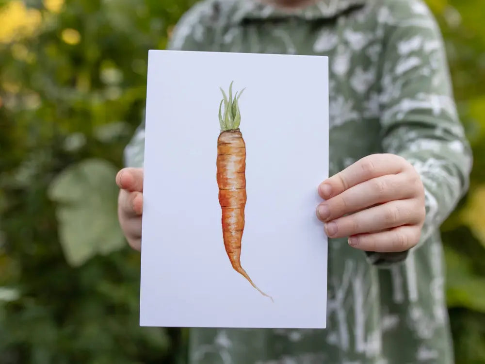Child holding carrot seasonal produce learning card with watercolor illustration