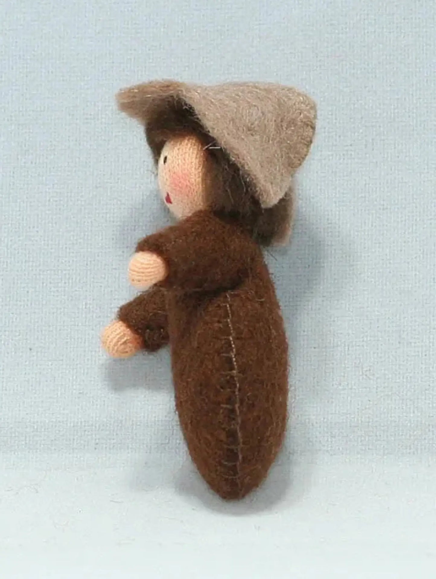 Side view of a seed baby ambrosia doll for nature tables on a white background