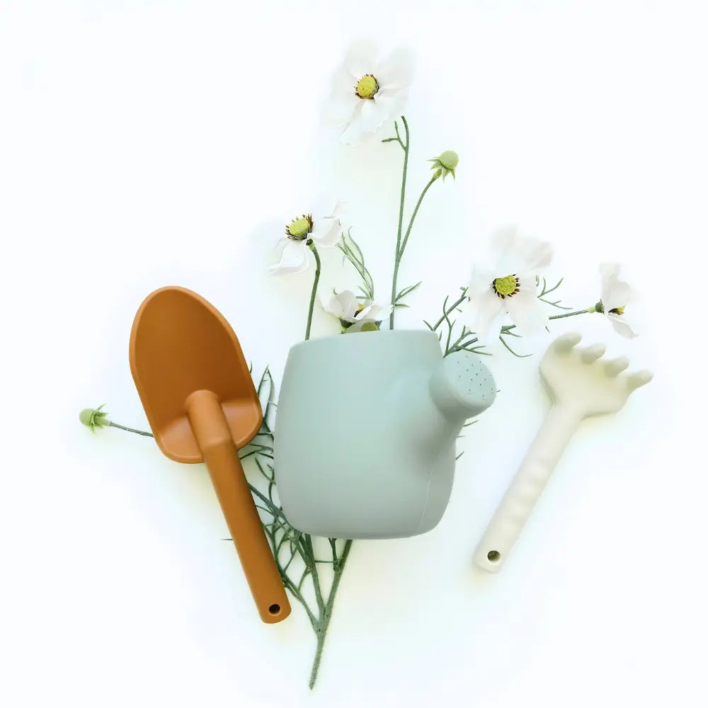 Children's silicone gardening tools with a small pot and flowers on a white background