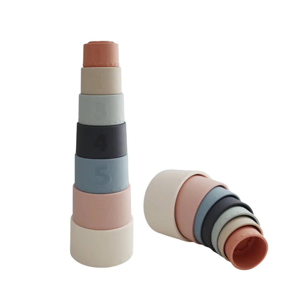 Set of colorful silicone baby nesting cups stacked on a white background