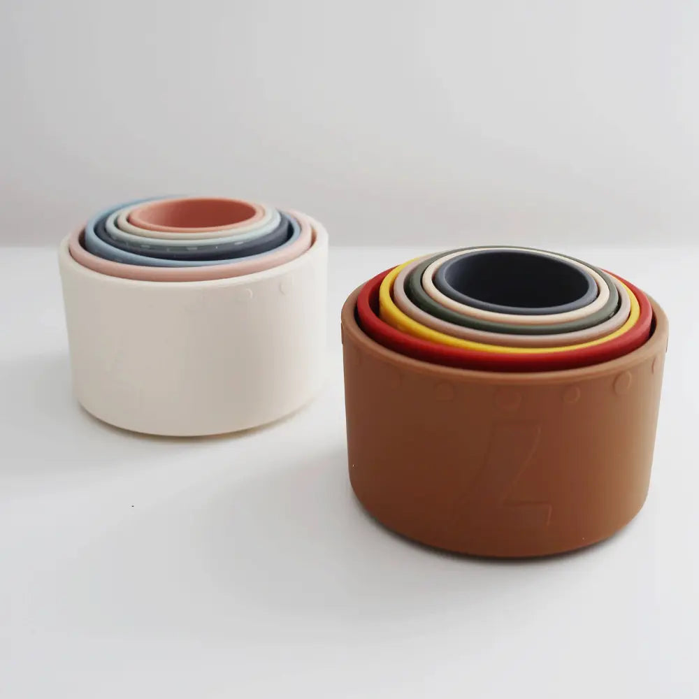 Two sets of silicone nesting cups in light colors and dark colors on light background