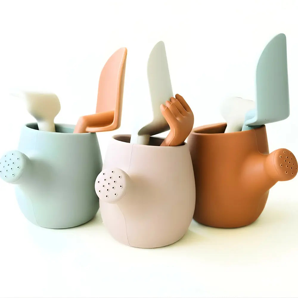 Set of three silicone garden and sand toys in different colors on a white background