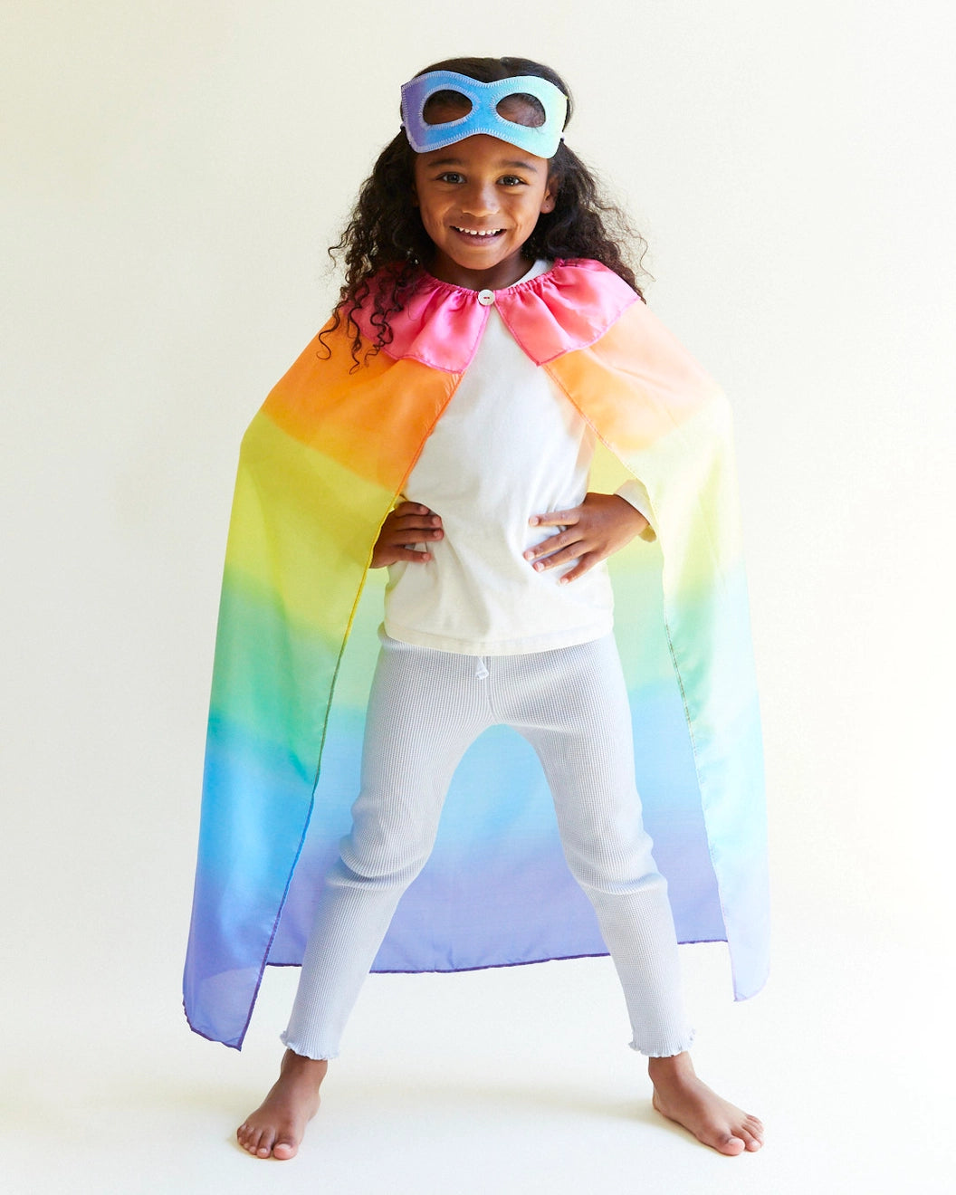 Child wearing a Sarah's Silks Rainbow Cape and crown with her hands on her hips