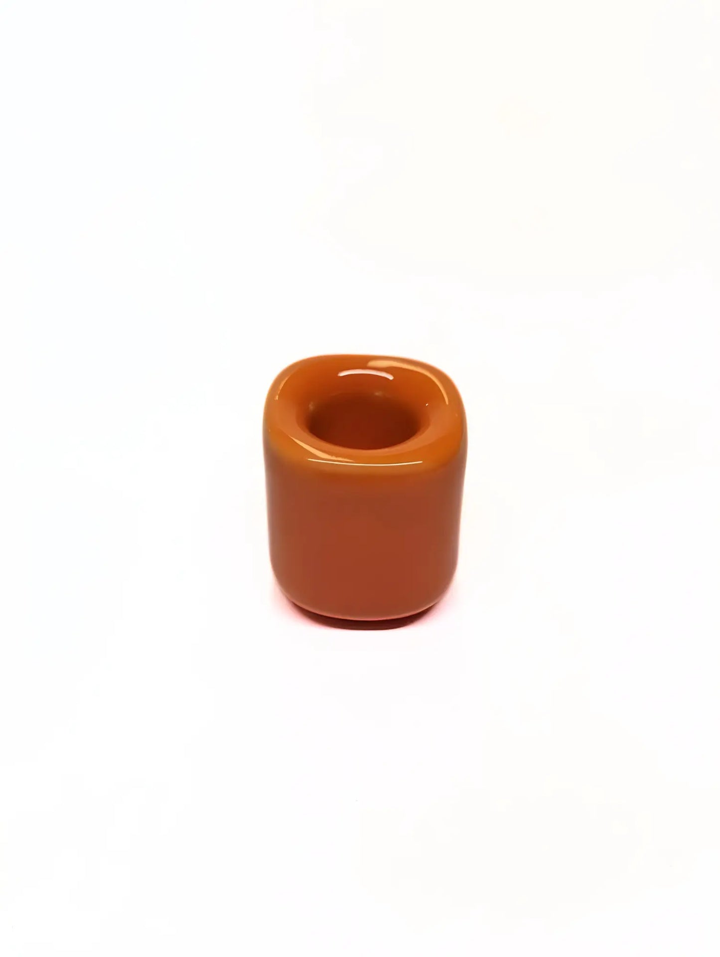 Orange ceramic taper candle holder on a white background