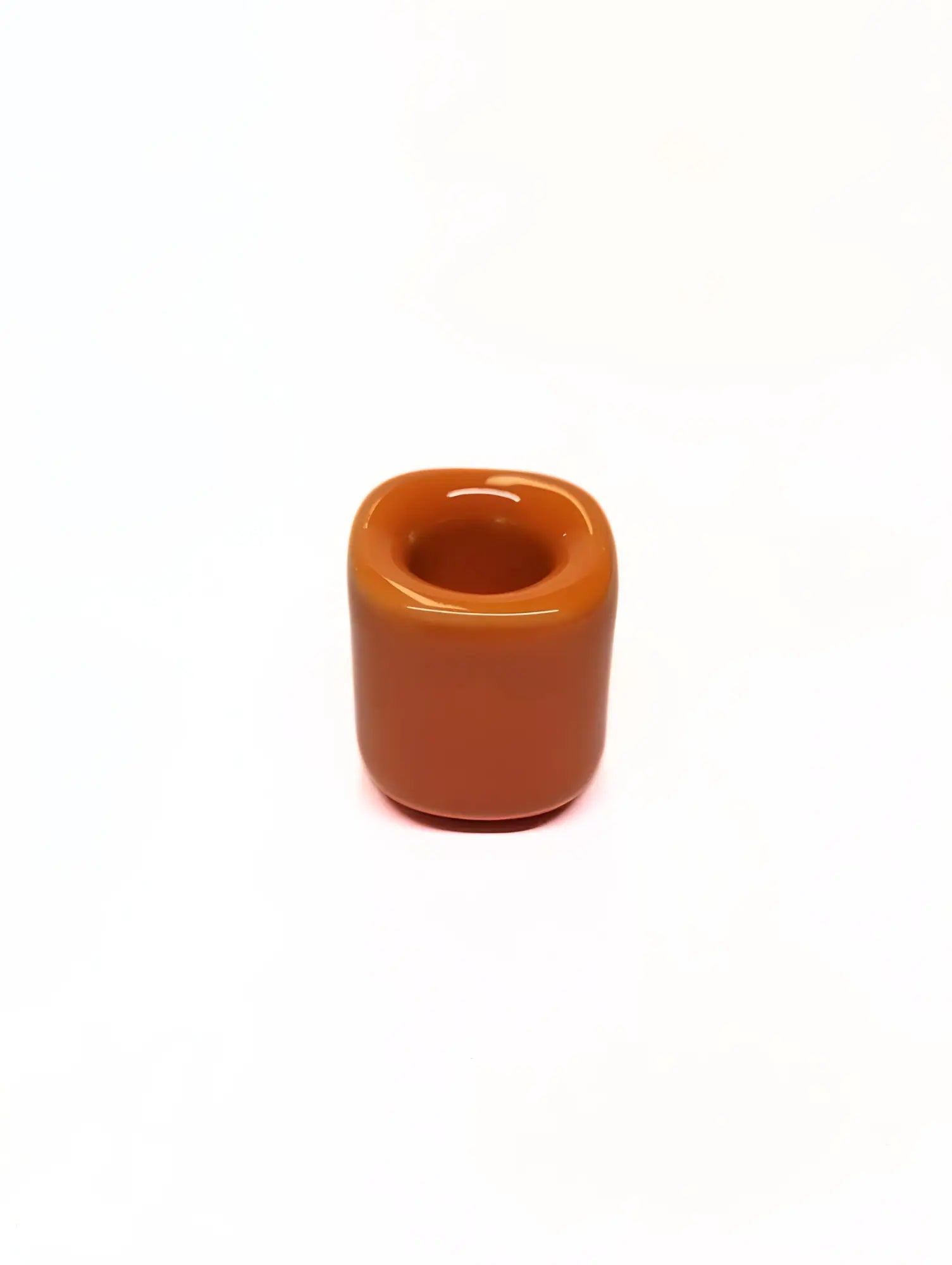 Orange ceramic taper candle holder on a white background