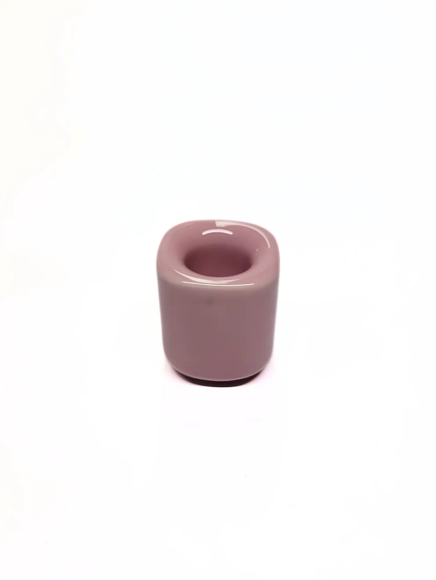 Pink ceramic taper candle holder on a white background