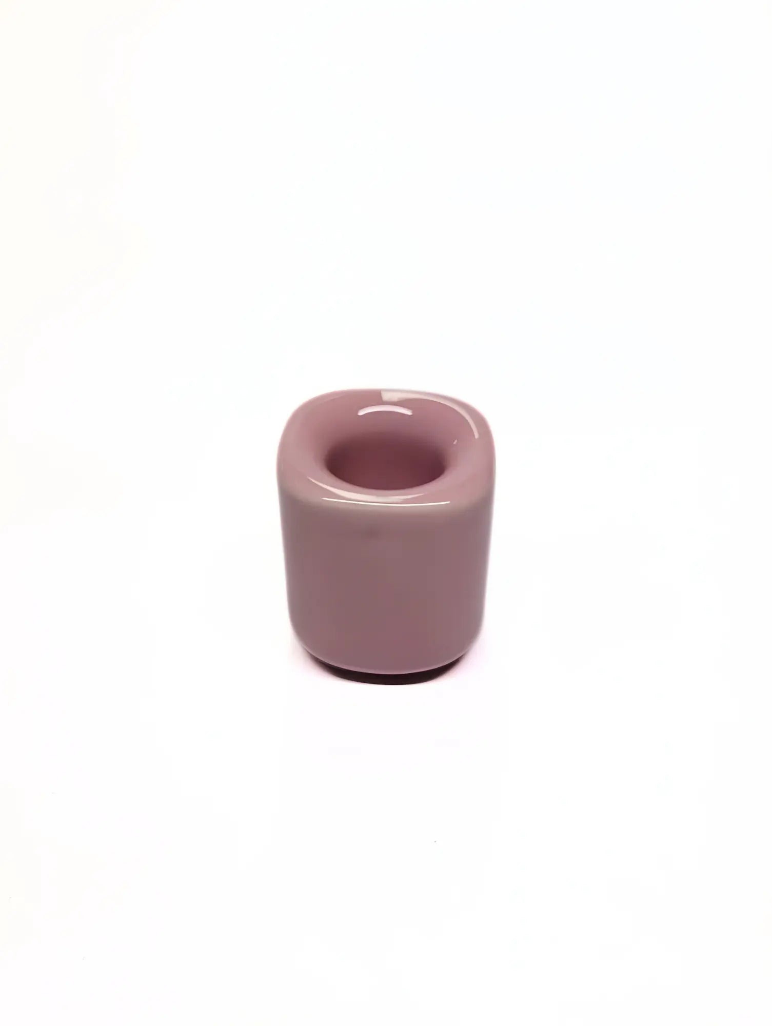 Pink ceramic taper candle holder on a white background