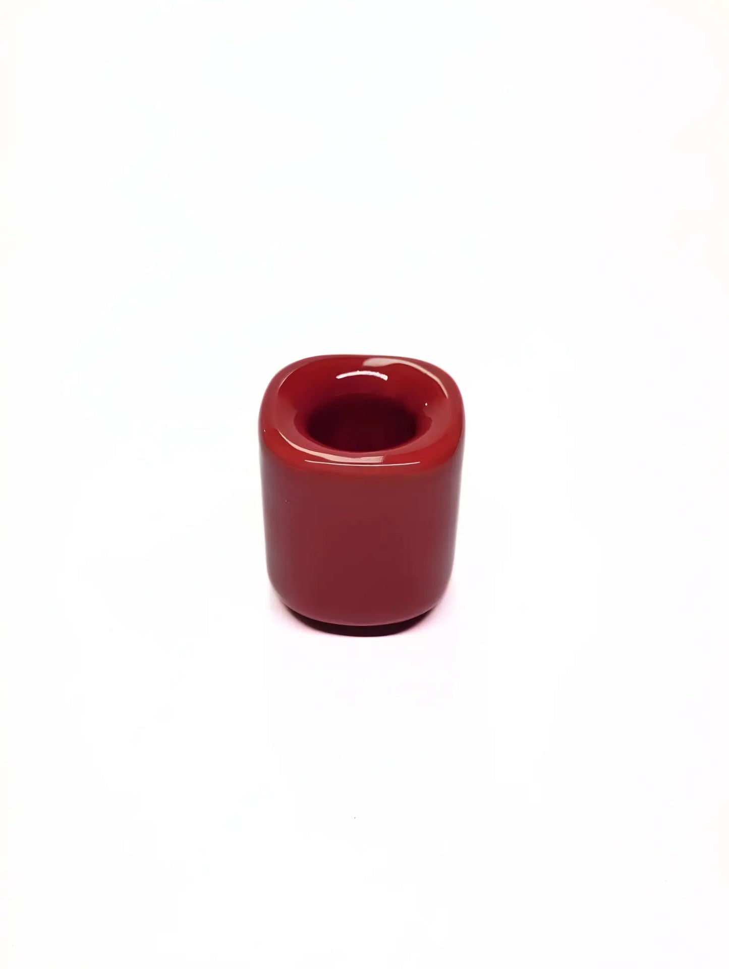 Red ceramic taper candle holder on a white background