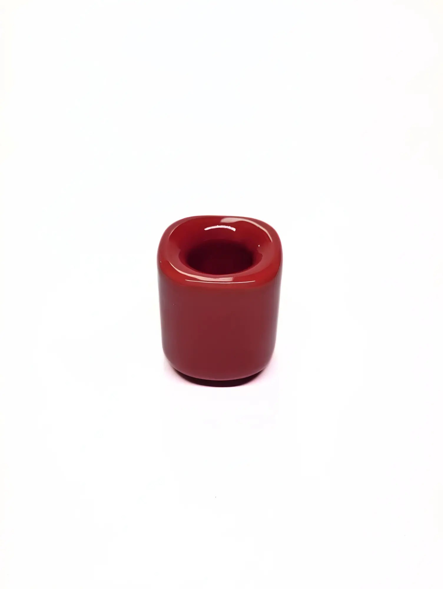 Red ceramic taper candle holder on a white background