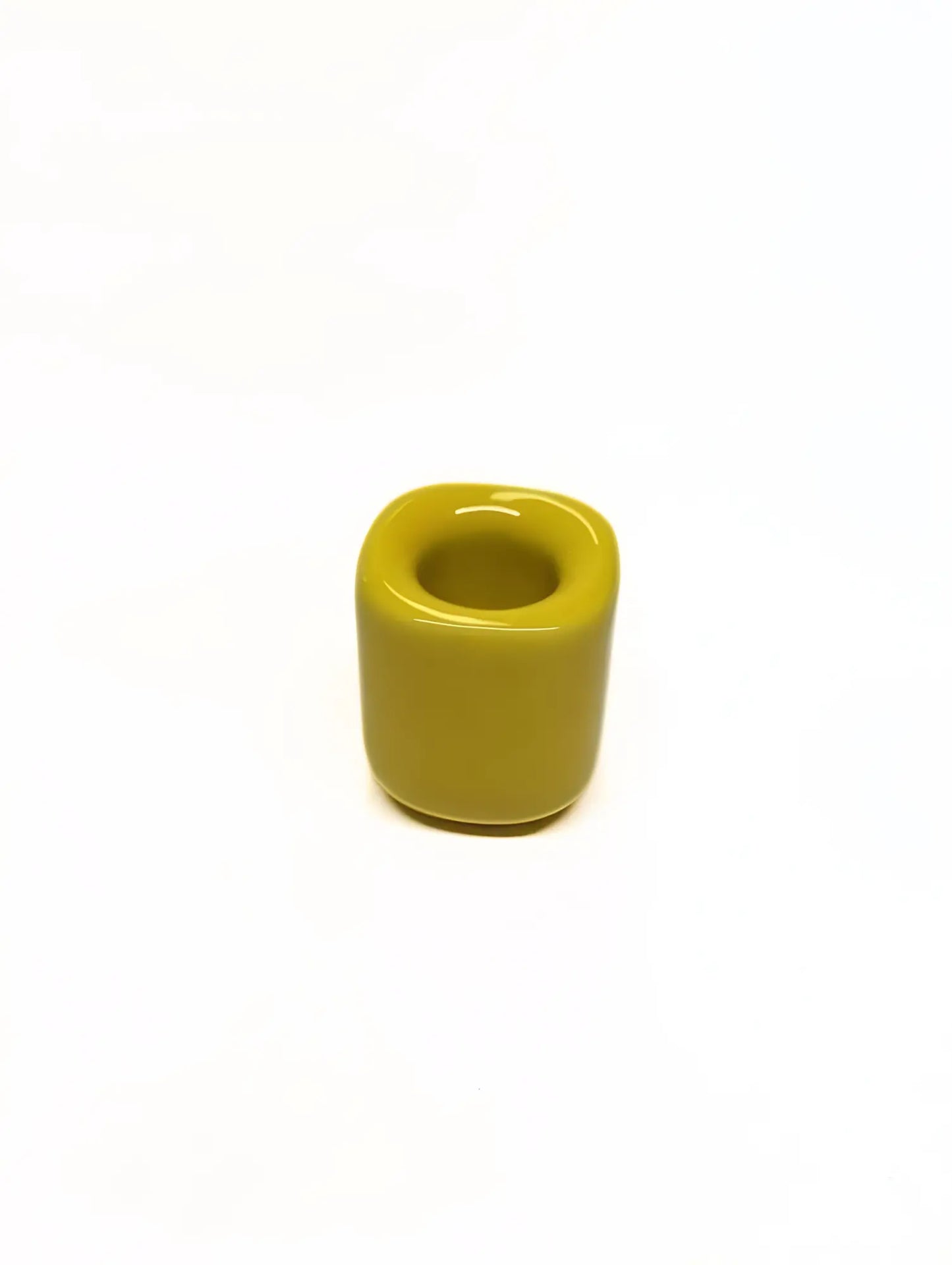 Yellow ceramic taper candle holder on a white background