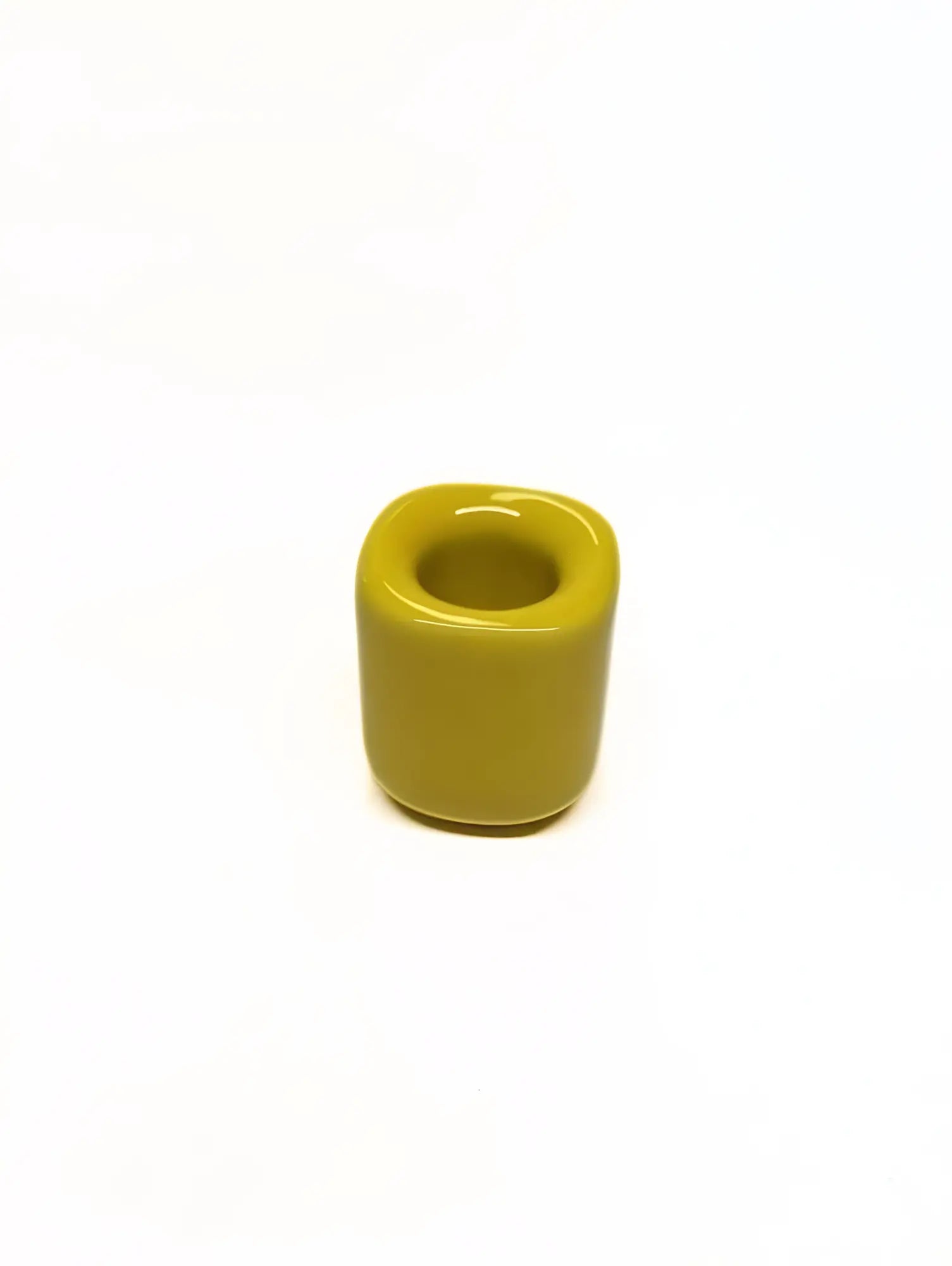 Yellow ceramic taper candle holder on a white background