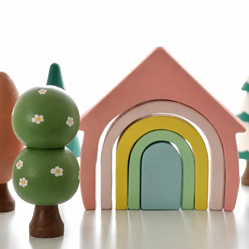 wooden tree next to a rainbow house for small world play