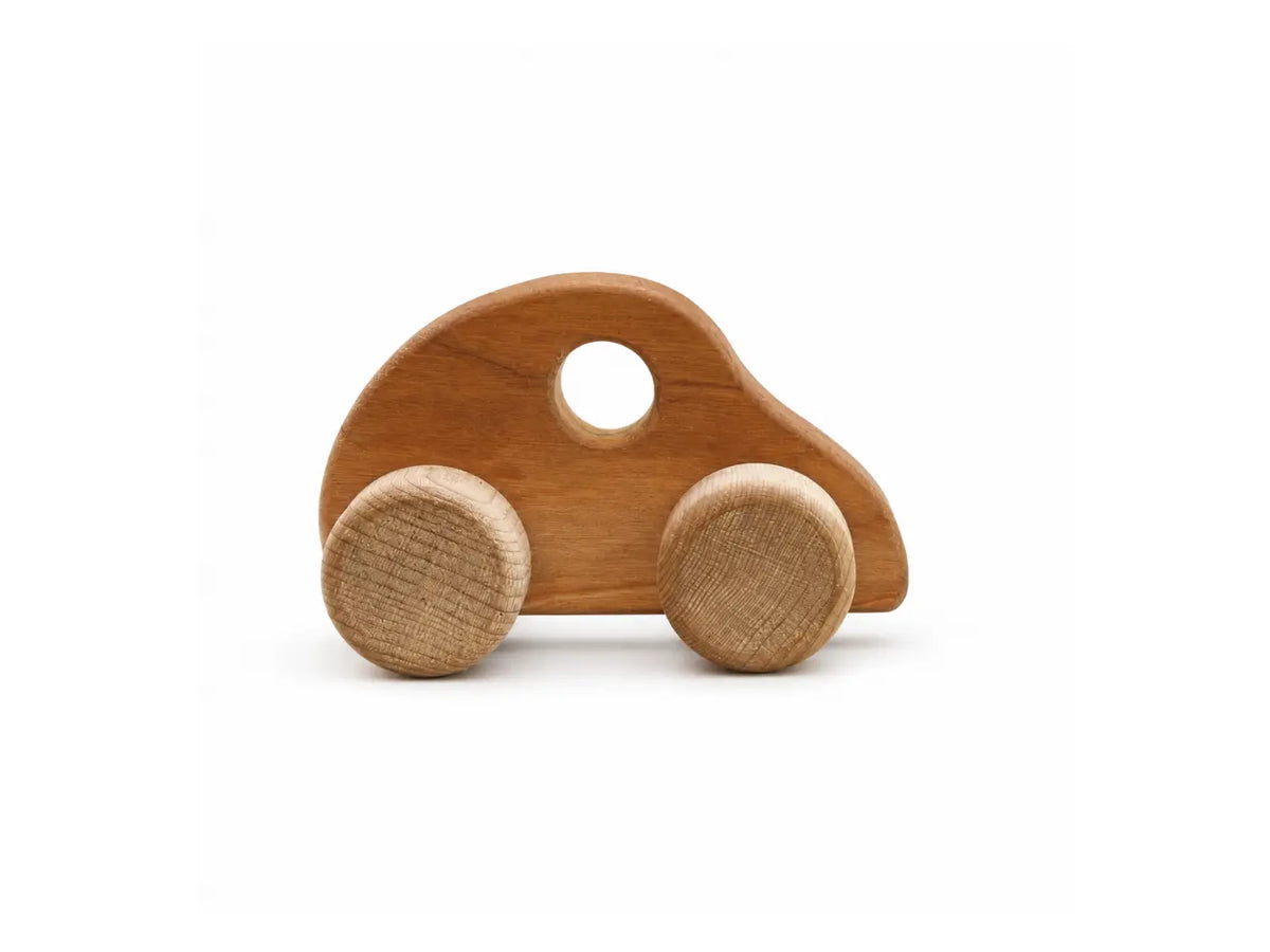Smaller wooden push car with cherry hardwood body and birch wheels on a white background.
