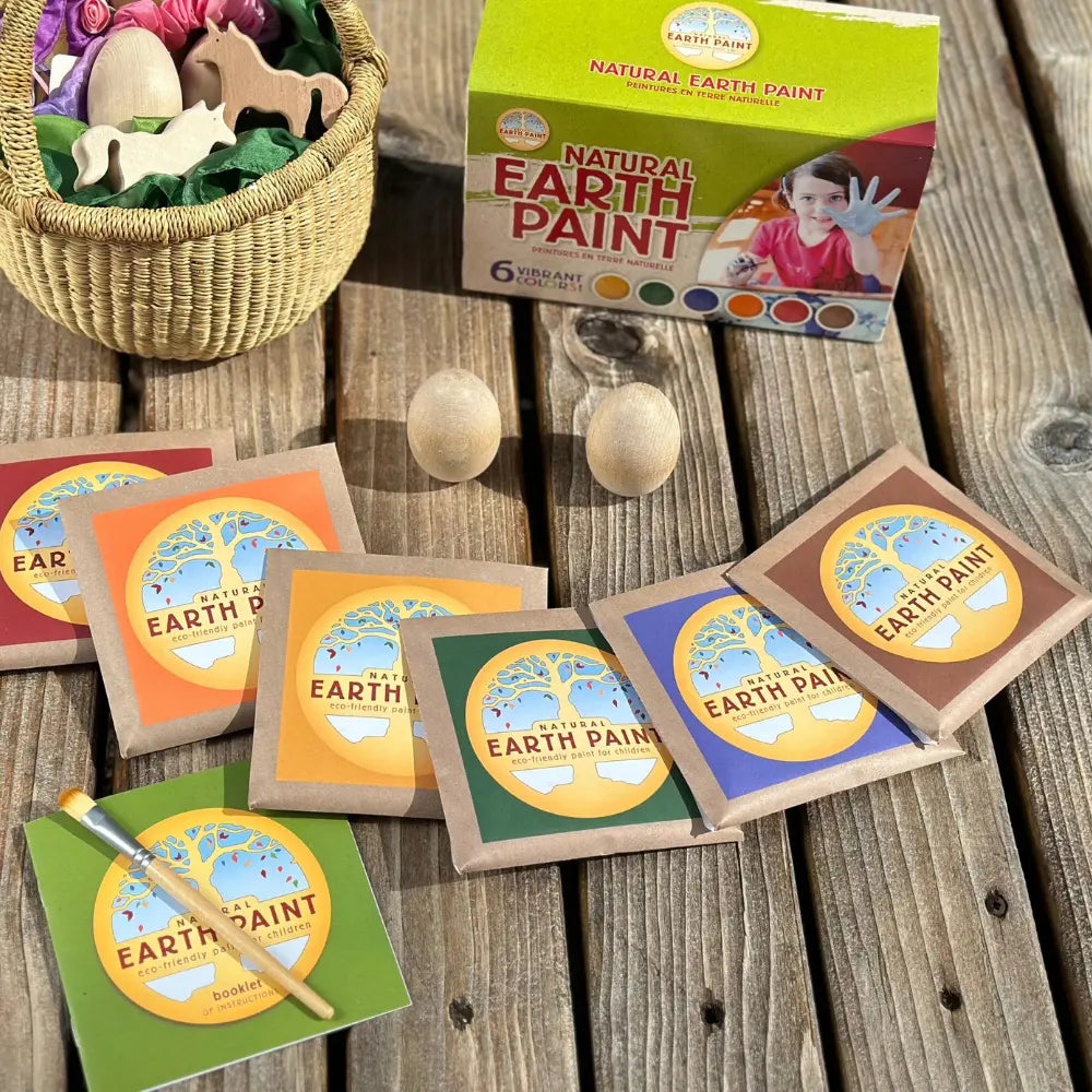 Natural Earth Paint set with paintbrushes on a wooden surface