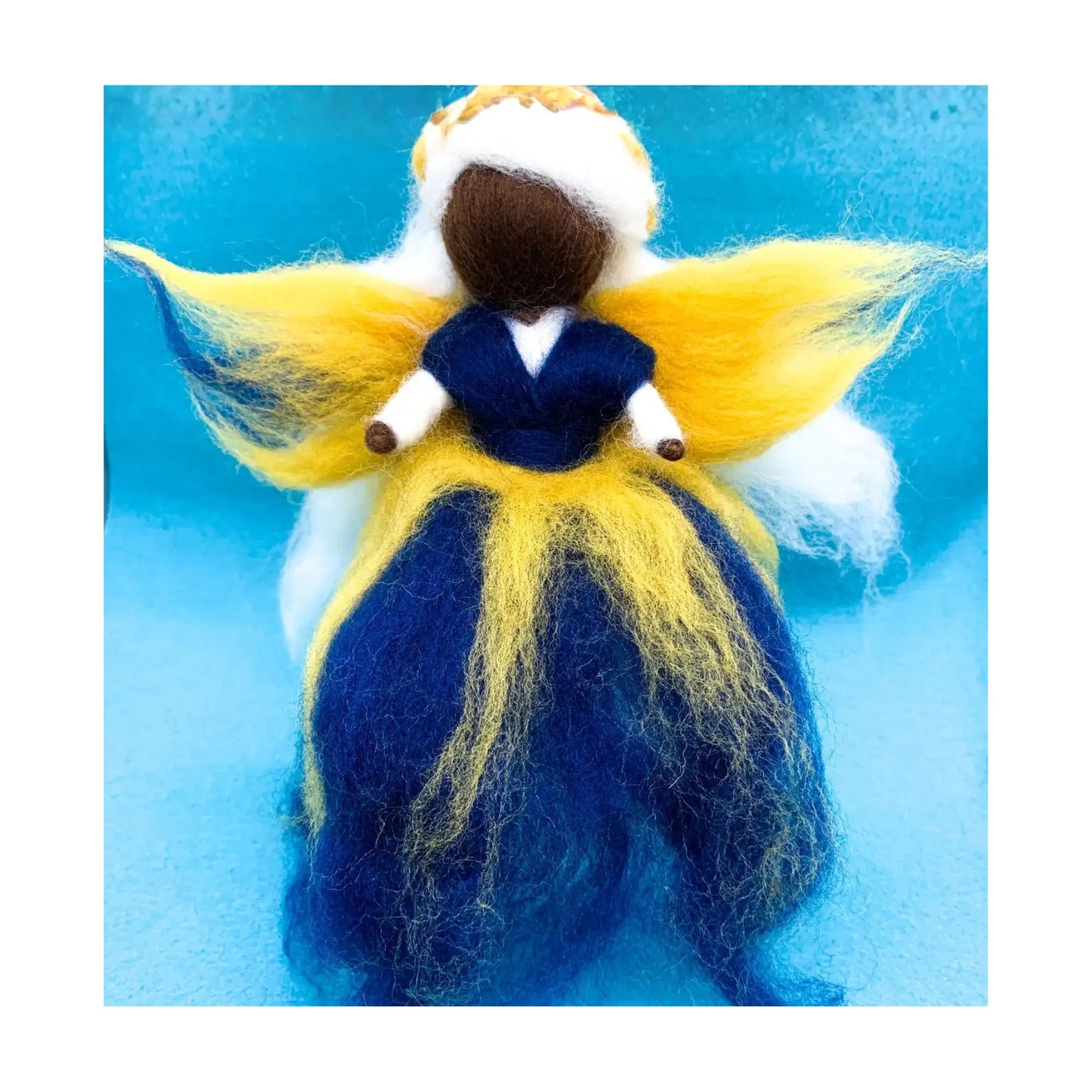 Felted fairy doll with yellow wings and blue dress on a blue background