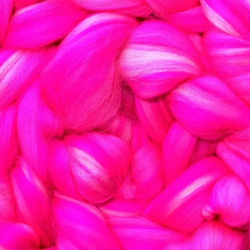 spinning colorful yarn from Merino wool top fiber in pinks and magentas