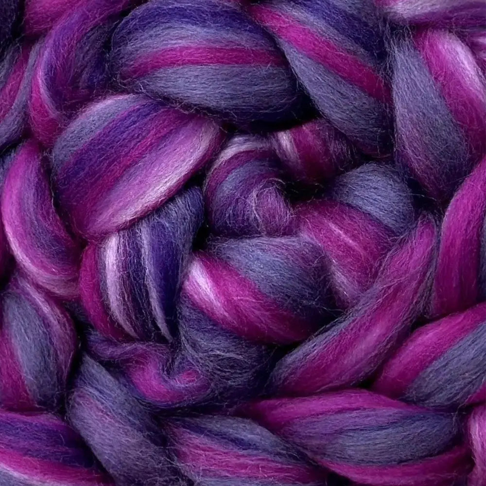 spinning colorful yarn from Merino wool top fiber in purple, pink, and lavender
