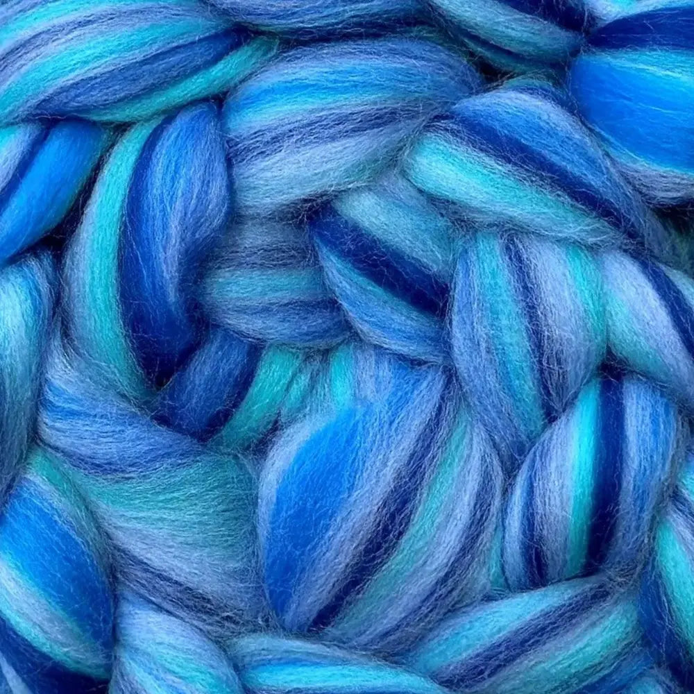 spinning colorful yarn from Merino wool top fiber in aqua, sky blue, and dark blue