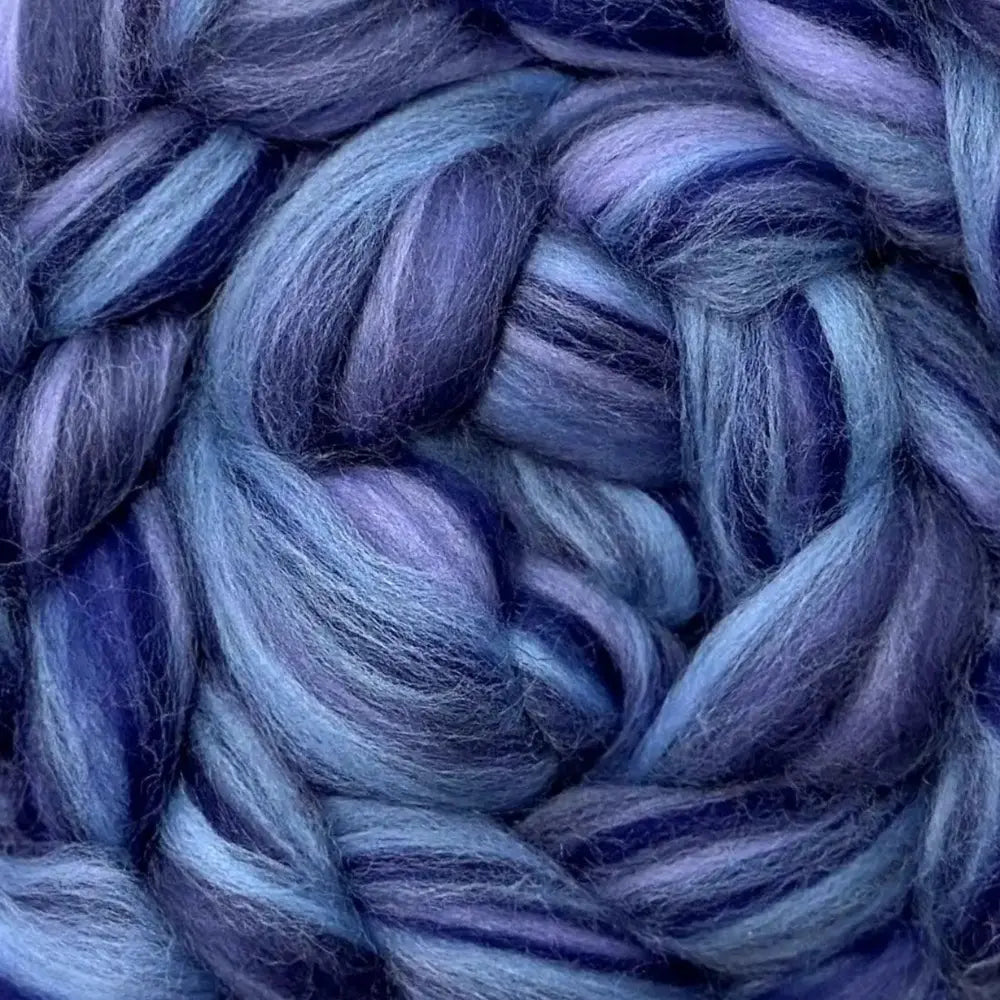 spinning colorful yarn from Merino wool top fiber in blue violet, light blue, dark purple