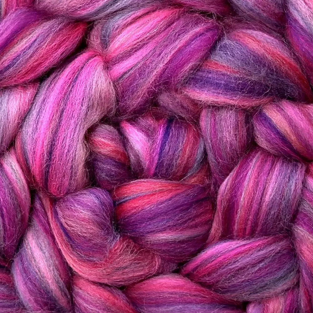 spinning colorful yarn from Merino wool top fiber in pink, purple, and cyclamen