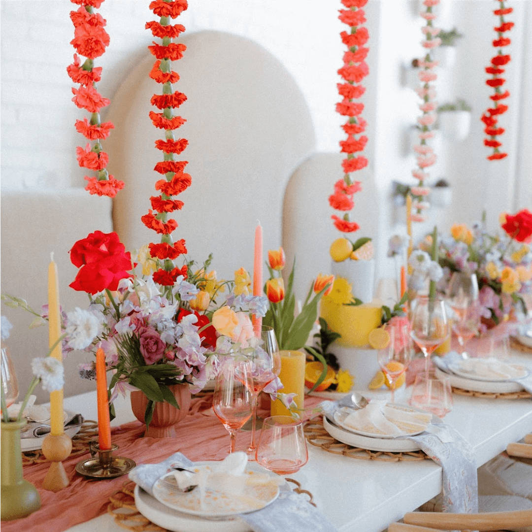 Decorative table setting with flowers and candles in a bright room.