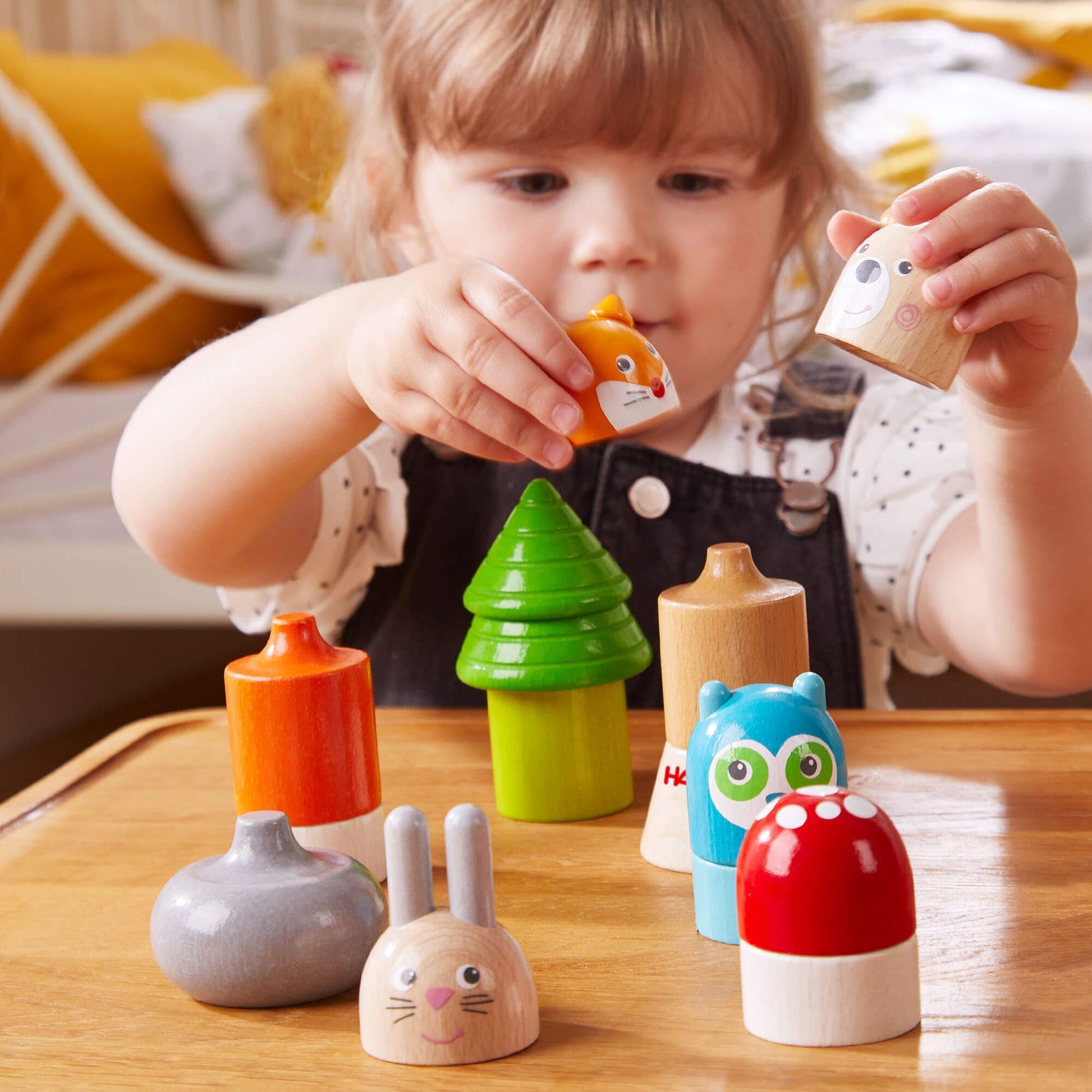 Child playing with colorful wooden toys on a table
