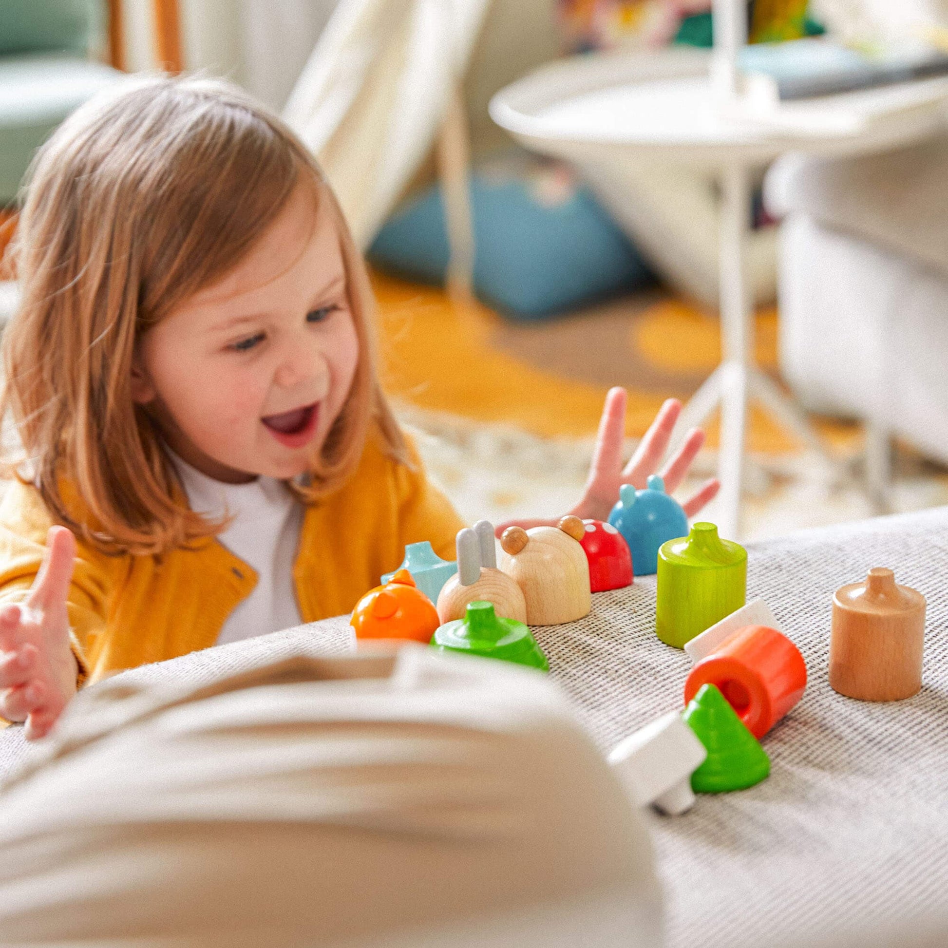 Child playing with colorful wooden toys on a rug