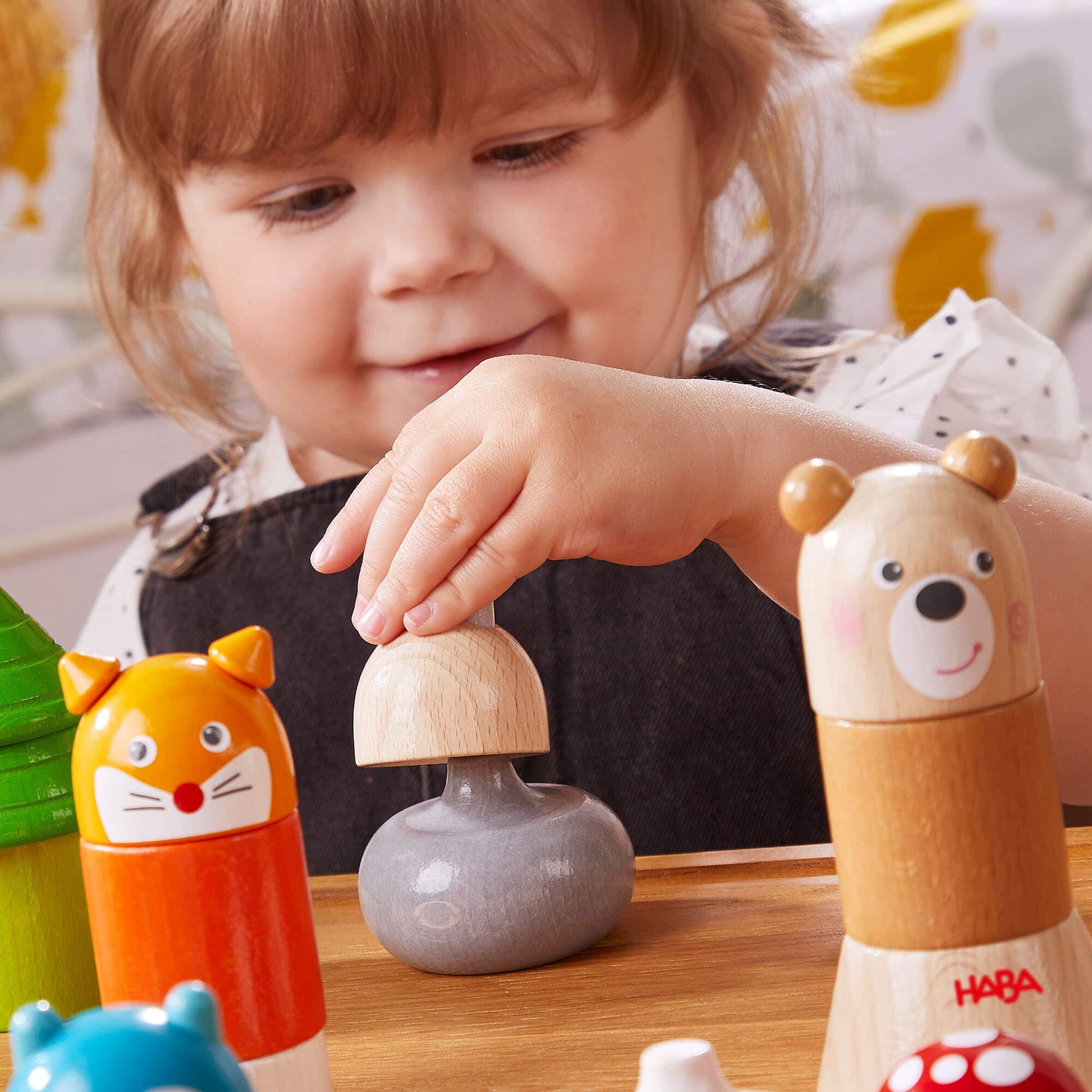 Child playing with wooden toys on a table