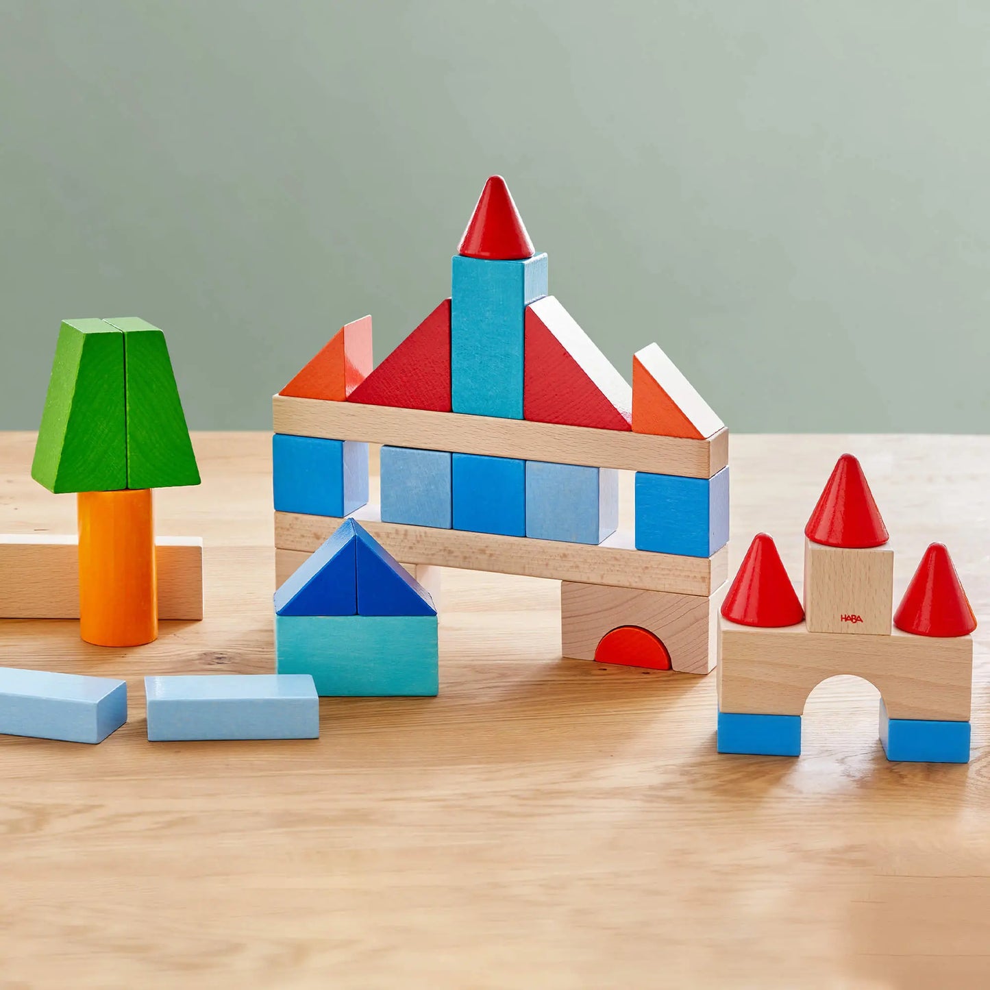 Colorful wooden building blocks on a wooden surface with a plain background