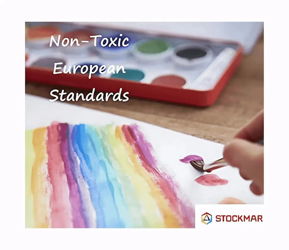 Colorful watercolor painting with a paint palette and brush, featuring Stockmar branding and non-toxic European standards text.