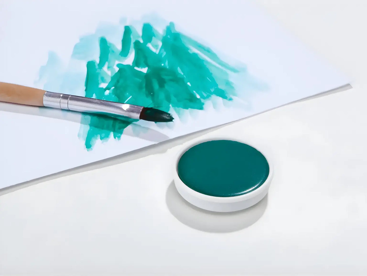 Blue Green Stockmar opaque paint with a brush on a white background