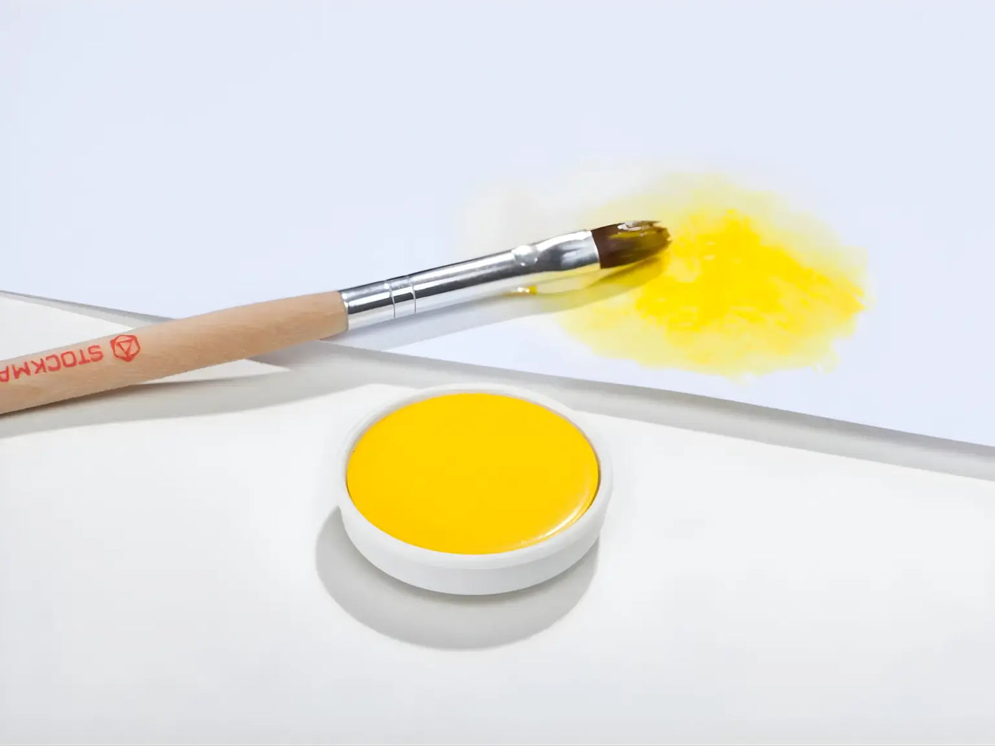 Lemon Yellow Stockmar opaque paint with a brush on a white background