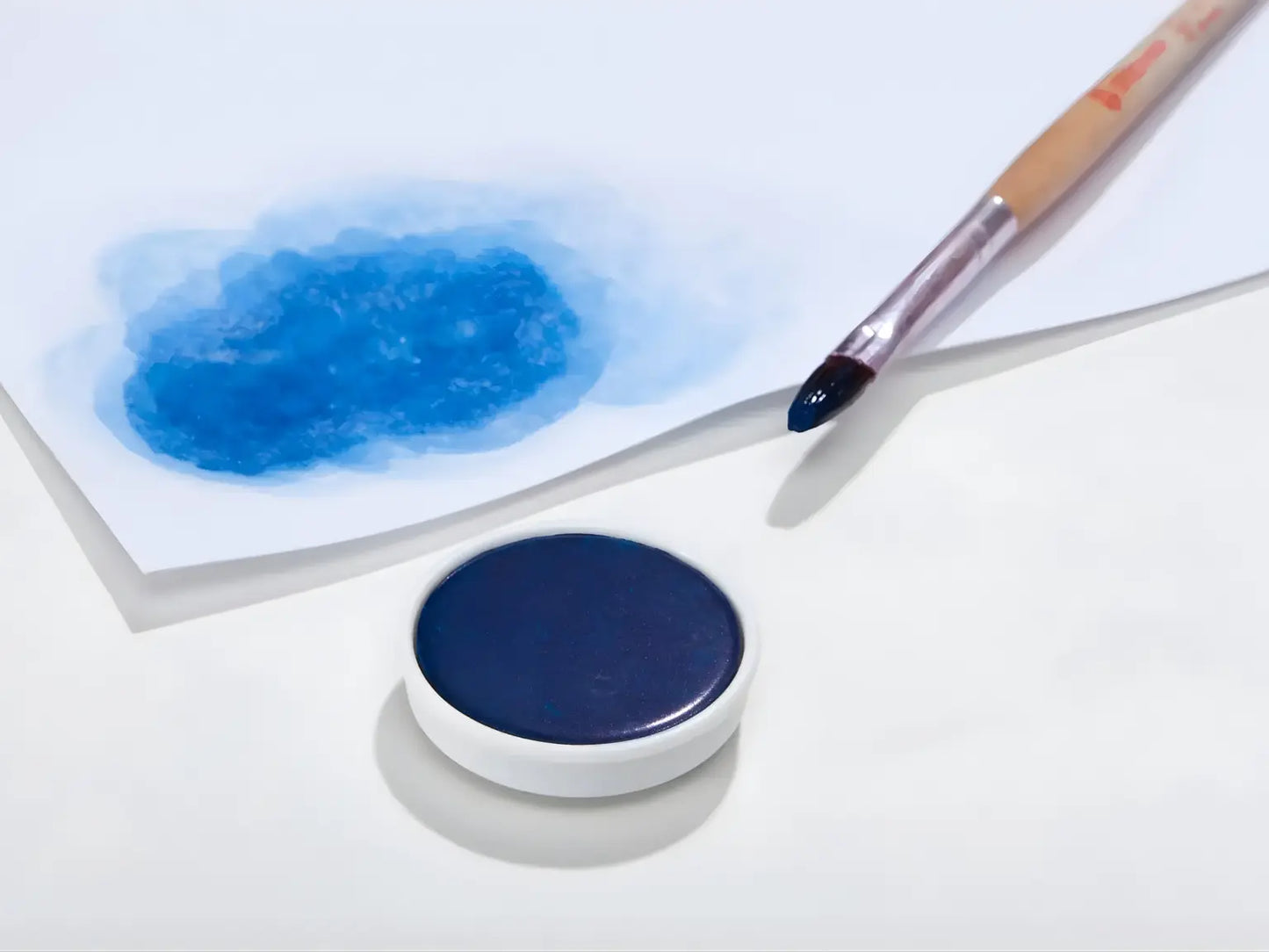 Prussian blue Stockmar opaque paint with a brush on a white background