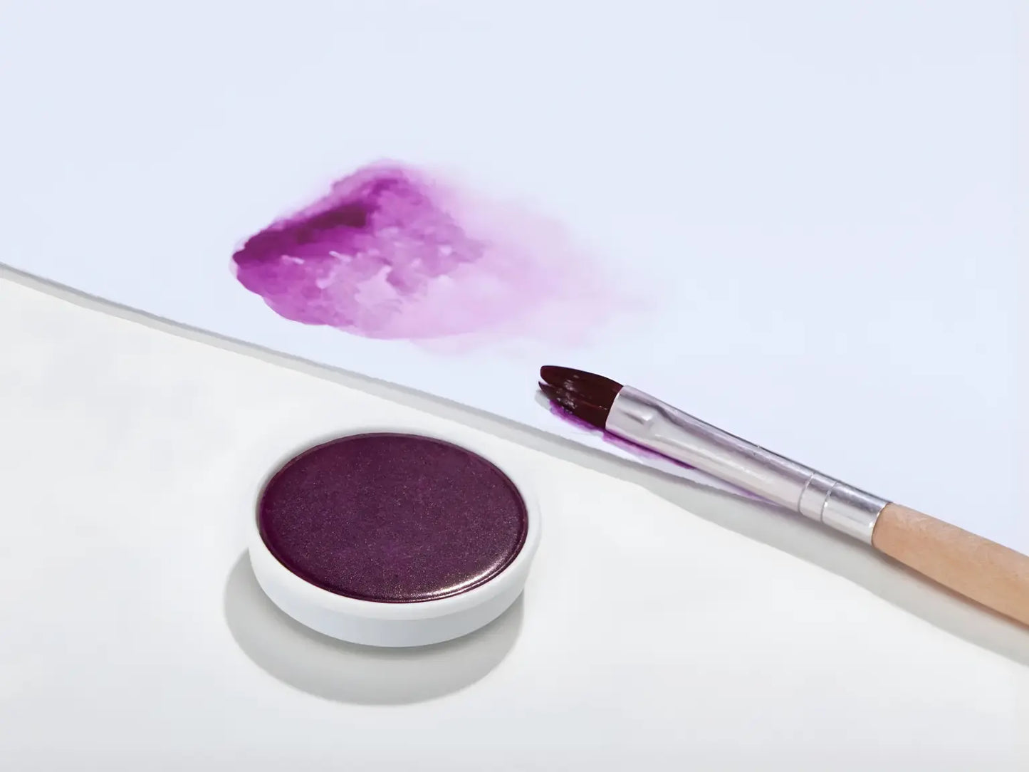 Red violet Stockmar opaque paint with a brush on a white background