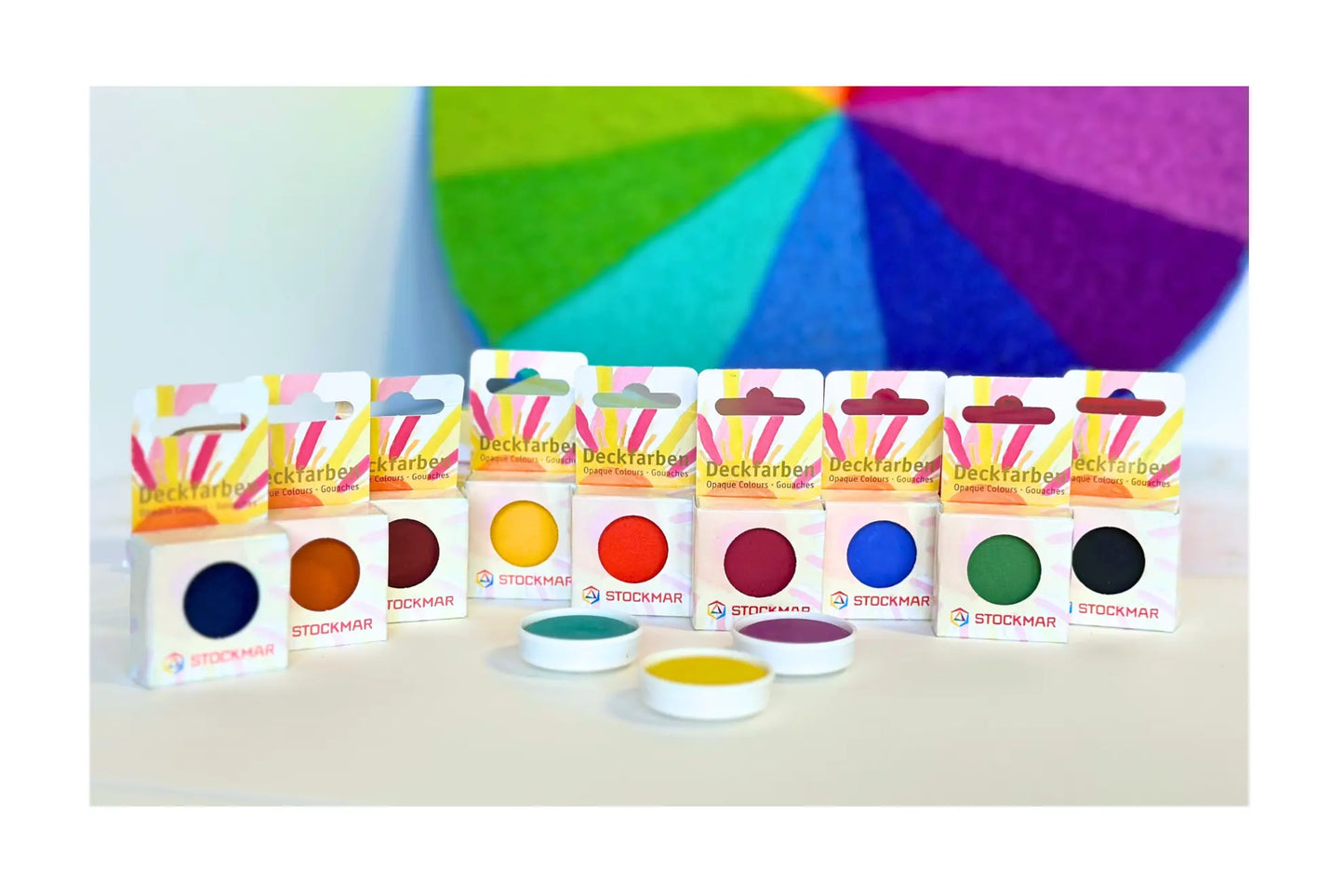 Stockmar Opaque Paint Colorbox Refill colors in a row in front of a color wheel
