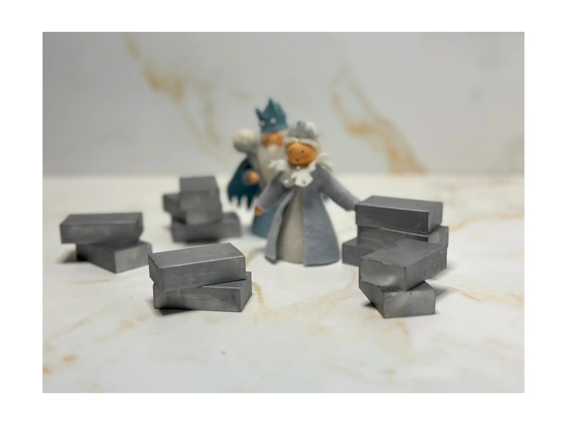 Small Stockmar silver block crayons and figurines on a marble surface