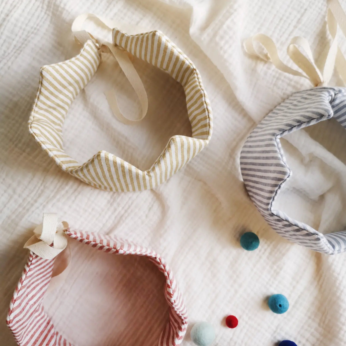Red, blue, and golden mustard striped linen crowns for children's dress-up play