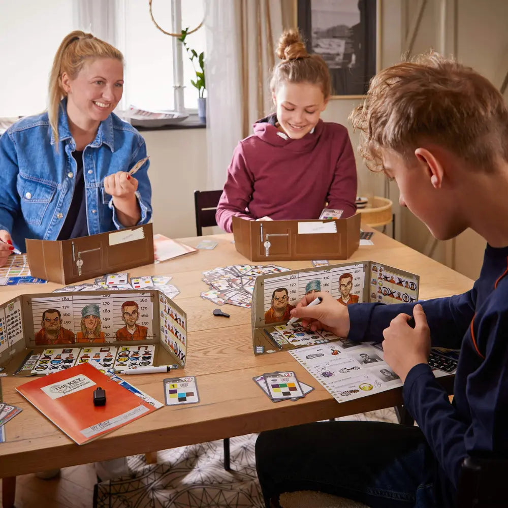 Three people playing a board game together at a table.